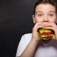 boy and hamburger - junk food stock pictures, royalty-free photos & images