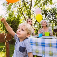 boy at table with family of three generations in garden - garden decoration stock pictures, royalty-free photos & images