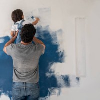 boy helping his father painting the house - home decoration stock pictures, royalty-free photos & images