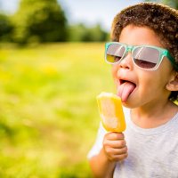 boy in sunglasses and hat eating popsicle outdoors - food stock pictures, royalty-free photos & images