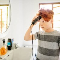 boy looking nervous while giving himself a haircut - hairstyle stock pictures, royalty-free photos & images