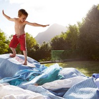 boy pretending to be a surfer in a suburban garden - garden decoration photos et images de collection