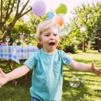 boy trying to catch soap bubbles in garden - garden decoration stock pictures, royalty-free photos & images