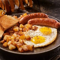 breakfast with sunny side up eggs and sausage - food stock pictures, royalty-free photos & images