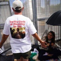 Brian Wood, a Taylor Swift fan from the United States, shows the back of his t-shirt as he waits at the Red Zone the VIP entrance to Wembley Stadium...