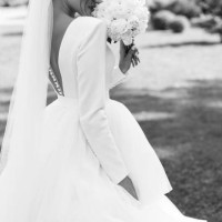 bride in a flowing white gown walks through a garden at an elegant wedding venue. - garden decoration stock pictures, royalty-free photos & images
