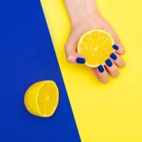 bright blue shiny creative manicure on yellow background. women's hands through a torn sheet of paper - nails art stock pictures, royalty-free photos & images
