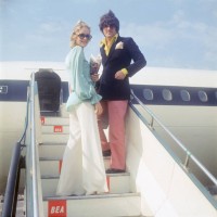 British fashion model Twiggy and her partner and manager Justin de Villeneuve board a BEA aircraft at London Airport, for a holiday in Greece, 24th...