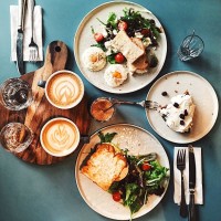 brunch for two people with avocado toast, fried egg, salad, cappuccino and carrot cake served on the table, high angle view - food stock pictures, royalty-free photos & images