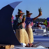 Buffett.hula.1010.ASIRVINEParrot heads Mike Berg, left, and Steve Mutt, both of San Diego, stand on an RV during a party in the parking lot...