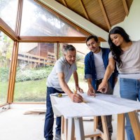 building contractor looking at blueprints with a couple remodeling their house - home decoration stock pictures, royalty-free photos & images
