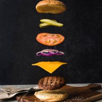 burger with separated floating ingredients on black background. - junk food stock pictures, royalty-free photos & images
