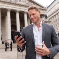 business man texting on his cell phone and having coffee to go - junk food stock pictures, royalty-free photos & images