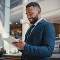 businessman, digital tablet or strategy planning in hotel conference lobby or airport travel lounge. happy smile, corporate worker or technology app to budget company finance or schedule target goals - travel stock pictures, 
