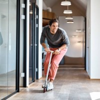 businessman enjoying on push scooter in office - fashion stock pictures, royalty-free photos & images