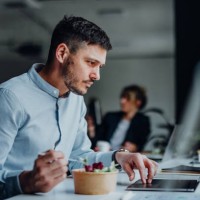 businessman having a lunch break at desk in the office - junk food stock pictures, royalty-free photos & images