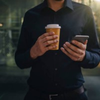businessman holding takeaway coffee and smartphone - junk food stock pictures, royalty-free photos & images