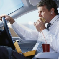 businessman sitting in car eating fast food, close-up - junk food stockfoto's en -beelden