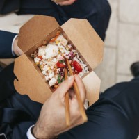 businessman taking a break and eating poke with take out box - junk food stock pictures, royalty-free photos & images