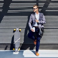 businessman with longboard and coffee leaning against wall - junk food stock pictures, royalty-free photos & images