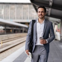 businessman with takeaway coffee walking on station platform - junk food stock pictures, royalty-free photos & images