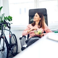 businesswoman having lunch break in office sitting at desk - junk food stock pictures, royalty-free photos & images