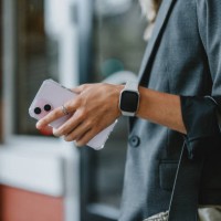 businesswoman holding smartwatch and smartphone in city street - fashion stock pictures, royalty-free photos & images