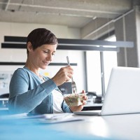 businesswoman in office having lunch break - food stock pictures, royalty-free photos & images