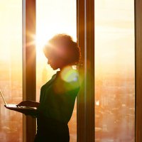 businesswoman on laptop at window in morning sun - hairstyle stock pictures, royalty-free photos & images