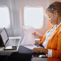 businesswoman reading documents and working on digital tablet during flight - travel stock pictures, royalty-free photos & images