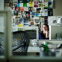 businesswoman sitting at desk in office smiling - home decoration stockfoto's en -beelden