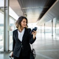 businesswoman walking while use phone at the airport - travel stock pictures, royalty-free photos & images