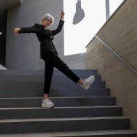 businesswoman wearing elegant suit dancing on steps in building - fashion stock pictures, royalty-free photos & images