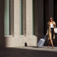 businesswoman with luggage walking outside airport - fashion stock pictures, royalty-free photos & images