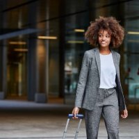 businesswoman with luggage walking outside office - travel stock pictures, royalty-free photos & images