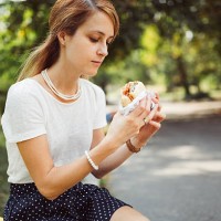 busy woman eating hamburger outside the office - junk food stock pictures, royalty-free photos & images