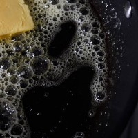 butter melting in pan - junk food stockfoto's en -beelden
