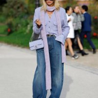 Candela Pelizza wears lilac tweed Chanel jacket, blue jeans, black Chanel belt, lilac knitted scarf, lilac Chanel bag, black sunglasses, Chanel...