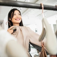 candid portrait of woman selecting clothing on rail - fashion stock pictures, royalty-free photos & images