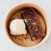 cardboard box of delicious fresh brownie and vanilla ice cream with nuts and citrus crumb on marble table. takeaway food - junk food stock pictures, royalty-free photos & images