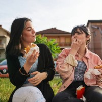 carefree friends eating take out food together - junk food stock pictures, royalty-free photos & images