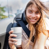 careless, young and happy woman is holding recycable takeaway coffee cup - junk food stock pictures, royalty-free photos & images