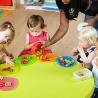 carer sert des fruits au groupe des bébés/enfants de la crèche - food photos et images de collection