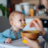 caring single father spoon feeding his beautiful son. - food stock pictures, royalty-free photos & images