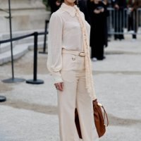 Carmella Rose wears beige blouse, beige trousers, brown bag, outside Zimmermann, during the Womenswear Fall/Winter 2025/2026 as part of Paris Fashion...