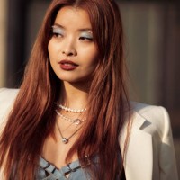 Caroline Hu is seen wearing a cream jacket, blue bralette, blue pearl jeans and white and gold chain Givenchy bag outside the Givenchy show during...