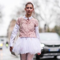 Caroline Takrarit wears a white shirt, a pastel pale pink floral embroidery t-shirt, a white tulle gathered / pleated mini skirt, floral embroidery...