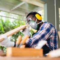 carpenter handling a piece of wood above his workbench in his workshop. - home decoration stock pictures, royalty-free photos & images