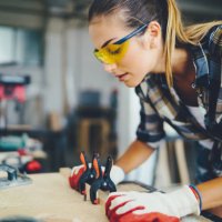 carpenter woman at work using electric saw to cut timber - home decoration stock pictures, royalty-free photos & images