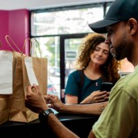 cashier looking food bag at restaurant - junk food stock pictures, royalty-free photos & images